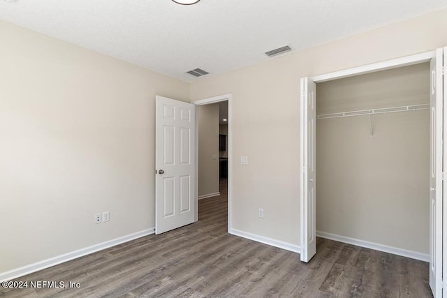 unfurnished bedroom with wood-type flooring and a closet