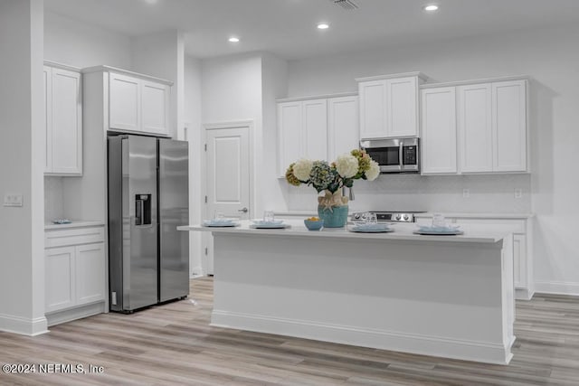 kitchen featuring light wood-type flooring, an island with sink, white cabinetry, and stainless steel appliances