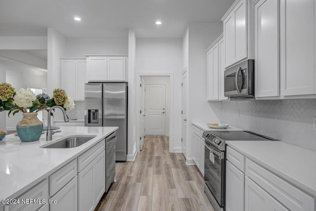 kitchen featuring light wood-type flooring, white cabinetry, sink, and stainless steel appliances