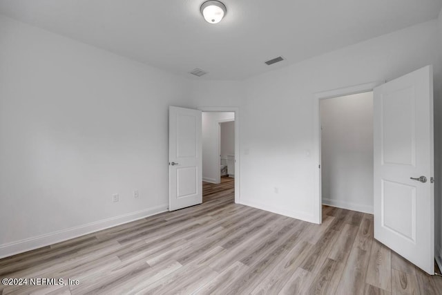 unfurnished bedroom with light hardwood / wood-style floors and a closet