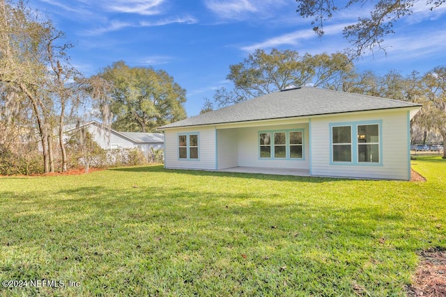 rear view of property with a lawn and a patio