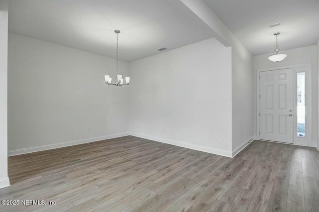 entrance foyer with a notable chandelier, visible vents, light wood-style flooring, and baseboards