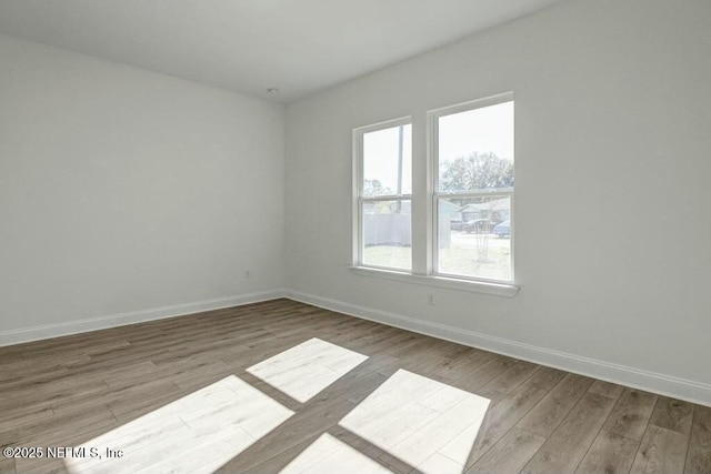 spare room with light wood-style floors and baseboards