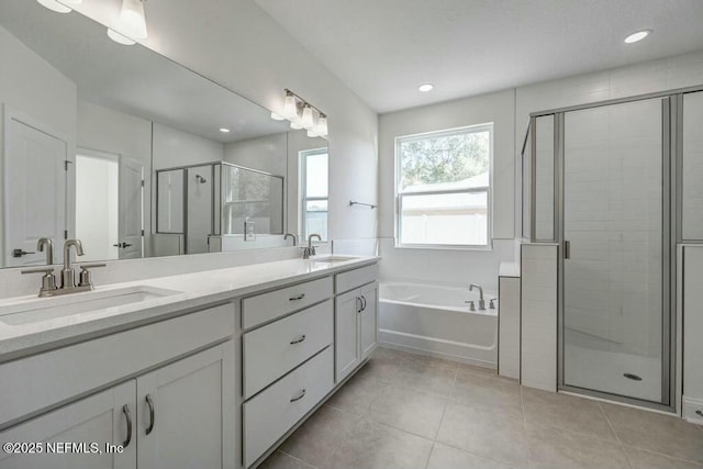 bathroom featuring double vanity, a shower stall, a sink, and tile patterned floors