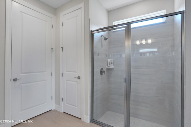 bathroom with a shower with door