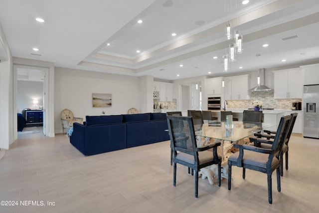 dining area with a raised ceiling and crown molding