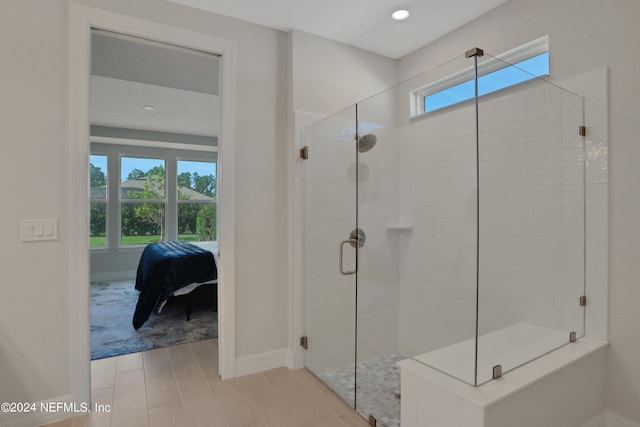 bathroom with a shower with door and a healthy amount of sunlight