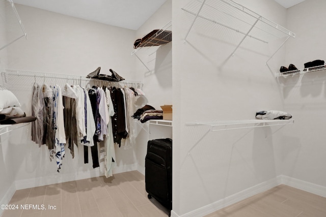 walk in closet with wood-type flooring