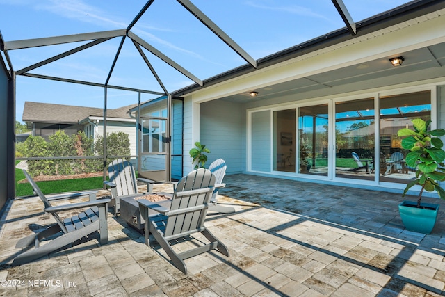 view of patio / terrace with a lanai and an outdoor fire pit