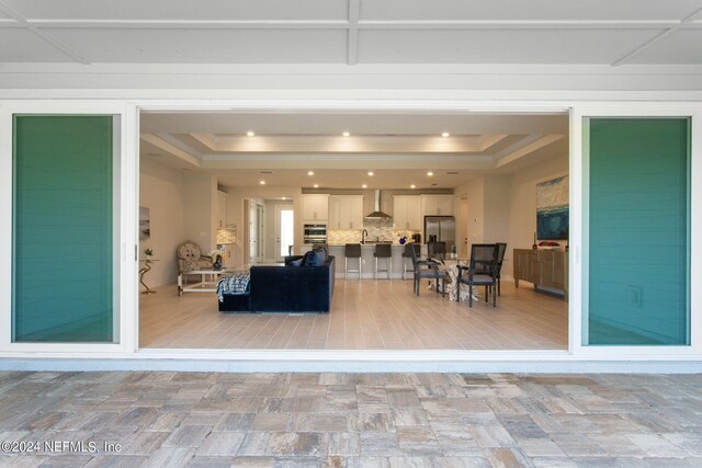 living room with a tray ceiling and ornamental molding