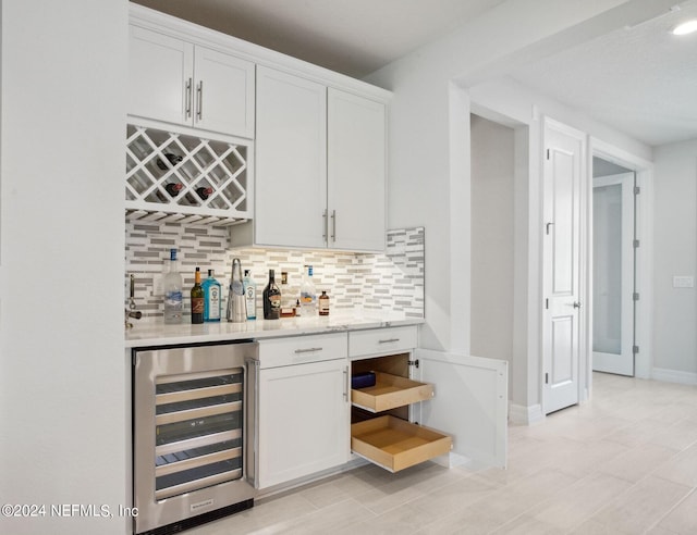 bar featuring white cabinets, wine cooler, and decorative backsplash