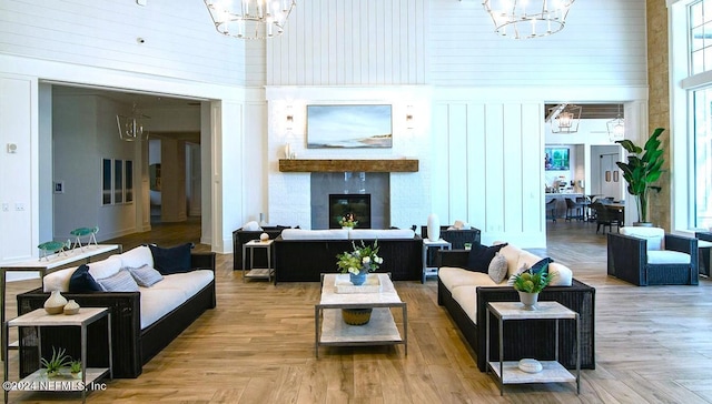 living room featuring a notable chandelier, a towering ceiling, parquet flooring, and a wealth of natural light