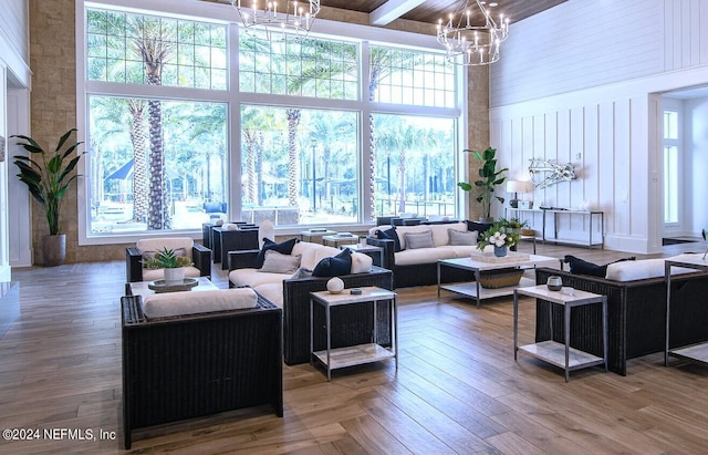 living room with a towering ceiling, an inviting chandelier, and plenty of natural light