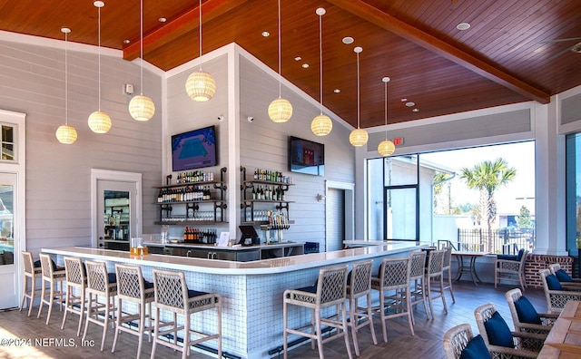 kitchen with pendant lighting, wood ceiling, beam ceiling, high vaulted ceiling, and a kitchen breakfast bar