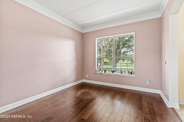 empty room with ornamental molding and wood-type flooring