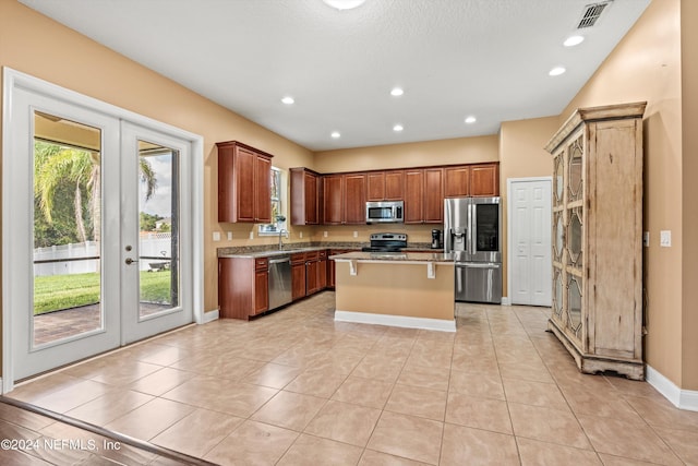 kitchen featuring a healthy amount of sunlight, a center island, stainless steel appliances, and french doors