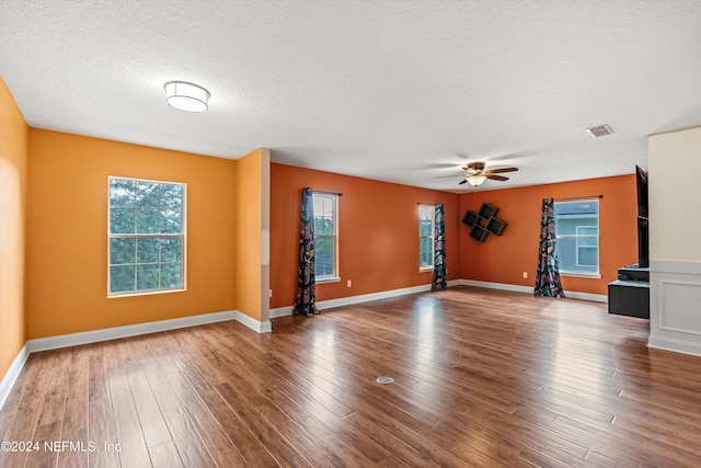 spare room featuring wood-type flooring, ceiling fan, and a textured ceiling