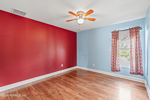 unfurnished room featuring ceiling fan, hardwood / wood-style flooring, and a textured ceiling