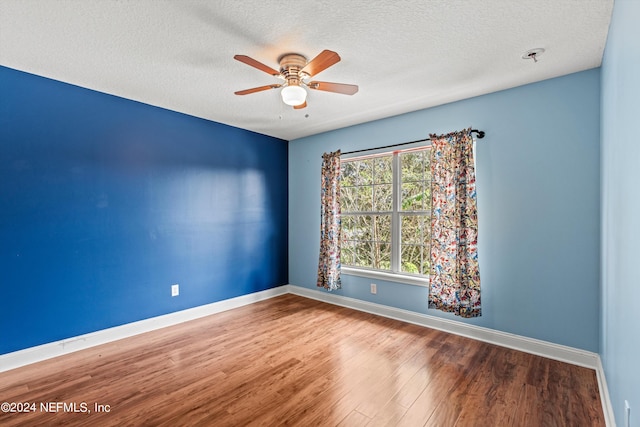 unfurnished room with a textured ceiling, wood-type flooring, and ceiling fan