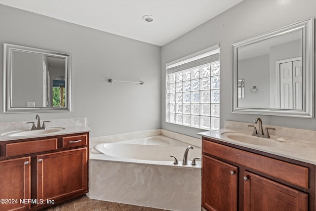 bathroom featuring a relaxing tiled tub, tile patterned flooring, and vanity