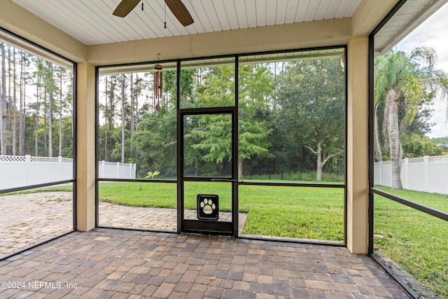 unfurnished sunroom with ceiling fan