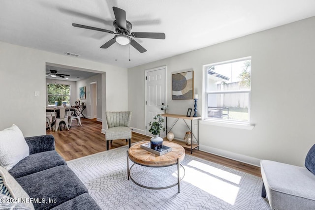 living room with ceiling fan, hardwood / wood-style flooring, and a healthy amount of sunlight