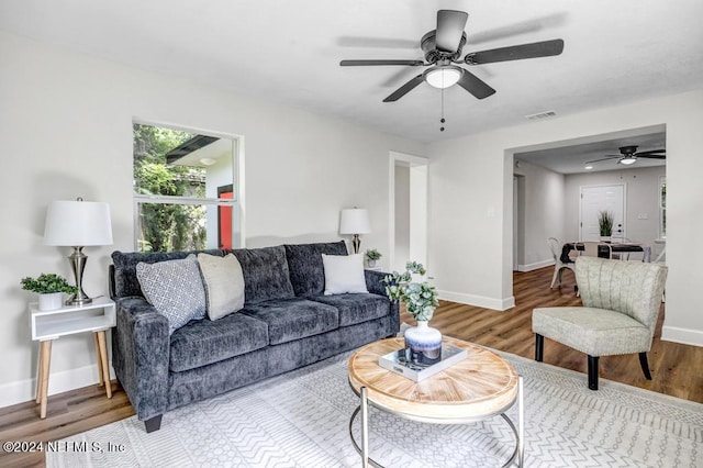 living room featuring wood-type flooring and ceiling fan