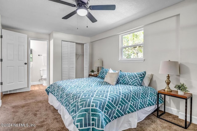 bedroom featuring ceiling fan, connected bathroom, a textured ceiling, carpet, and a closet