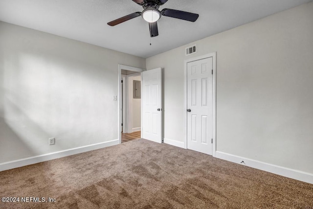 unfurnished bedroom with ceiling fan, carpet floors, a closet, and electric panel