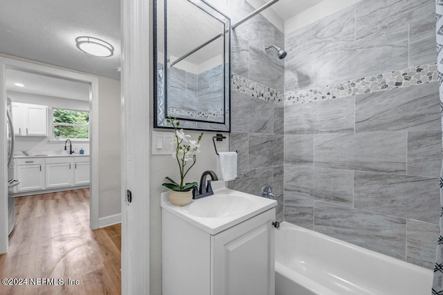 bathroom featuring tiled shower / bath combo, vanity, and hardwood / wood-style flooring