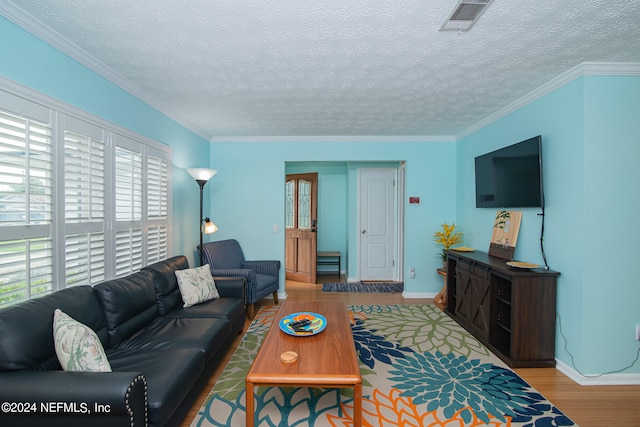 living room with a textured ceiling, ornamental molding, and hardwood / wood-style floors