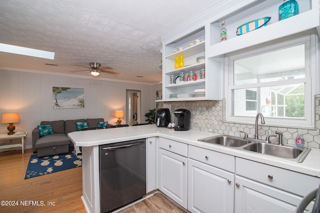 kitchen with light hardwood / wood-style flooring, kitchen peninsula, dishwasher, and a skylight