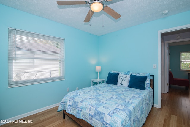 bedroom featuring a textured ceiling, ceiling fan, and hardwood / wood-style flooring