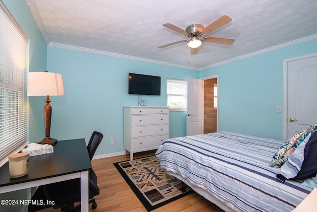 bedroom featuring ornamental molding, light hardwood / wood-style floors, ceiling fan, and a textured ceiling