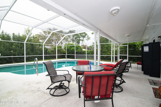 view of swimming pool with glass enclosure and a patio area