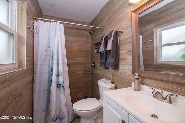 bathroom with walk in shower, vanity, toilet, and a textured ceiling