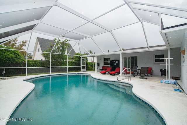 view of swimming pool featuring a patio and glass enclosure