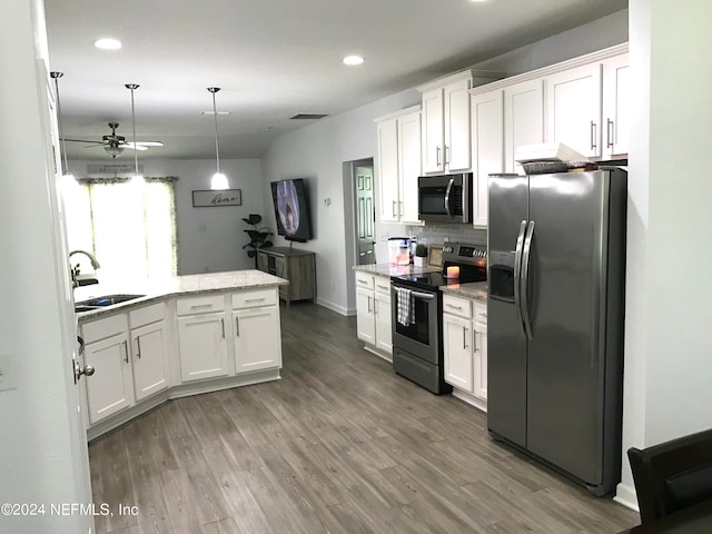 kitchen with hanging light fixtures, white cabinets, stainless steel appliances, ceiling fan, and hardwood / wood-style flooring