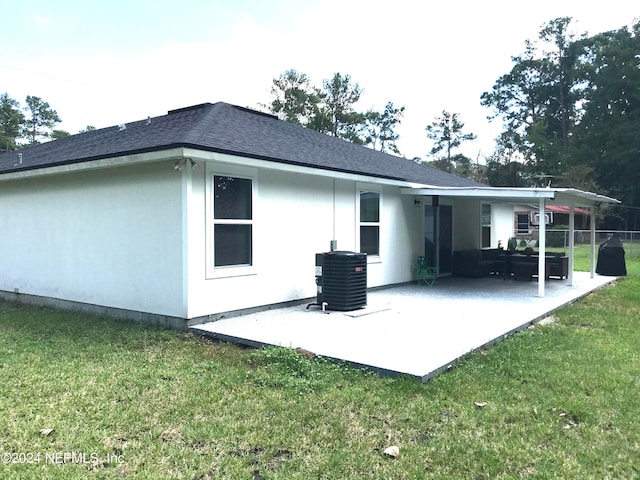 rear view of property with a patio, a yard, and central AC unit