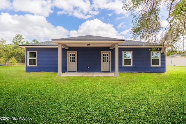 back of house with a patio area and a yard