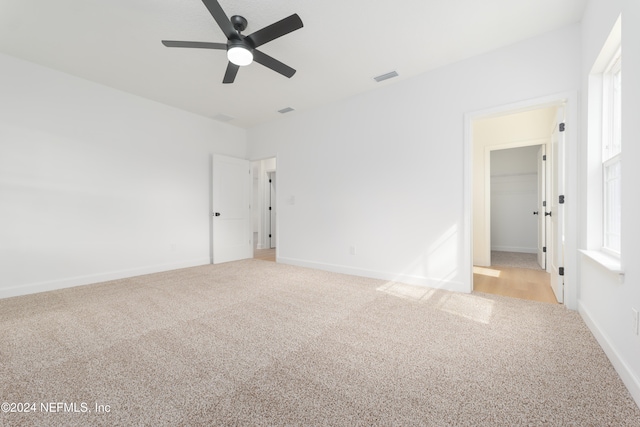 carpeted spare room with ceiling fan