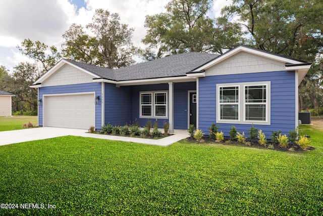 view of front facade with a garage, cooling unit, and a front yard