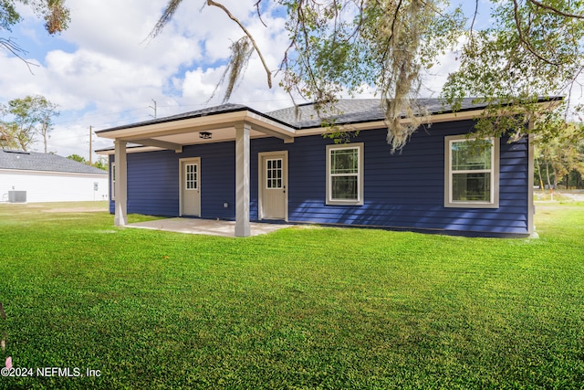 back of house featuring cooling unit, a lawn, and a patio area