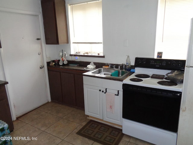 kitchen featuring electric stove, white cabinetry, sink, and light tile patterned flooring