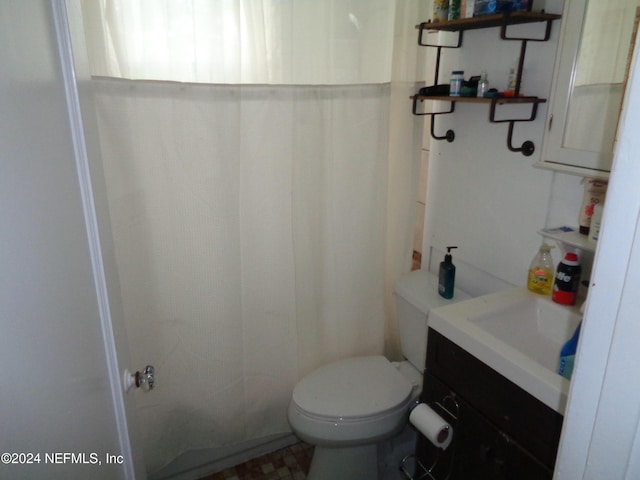 bathroom with vanity, toilet, and curtained shower