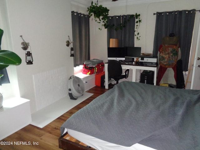 bedroom with wood-type flooring and crown molding