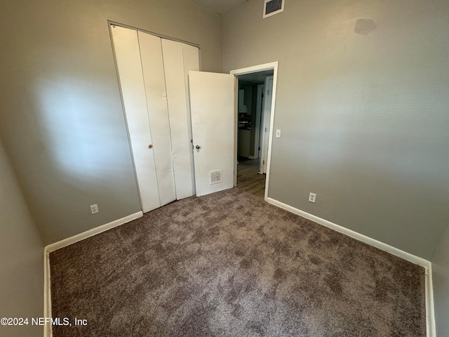 unfurnished bedroom with a closet and carpet floors