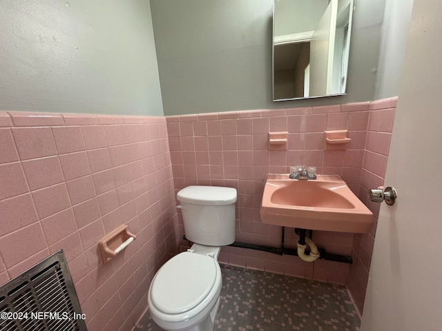 bathroom with tile walls, sink, and toilet