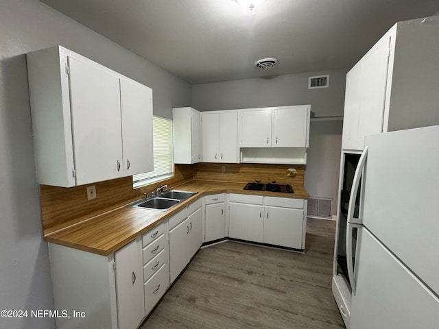 kitchen featuring white cabinetry, sink, and white fridge