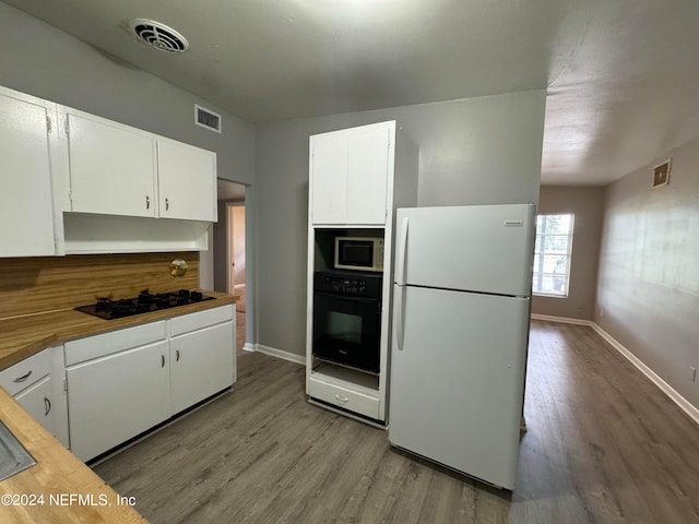 kitchen with light hardwood / wood-style flooring, white cabinetry, and black appliances